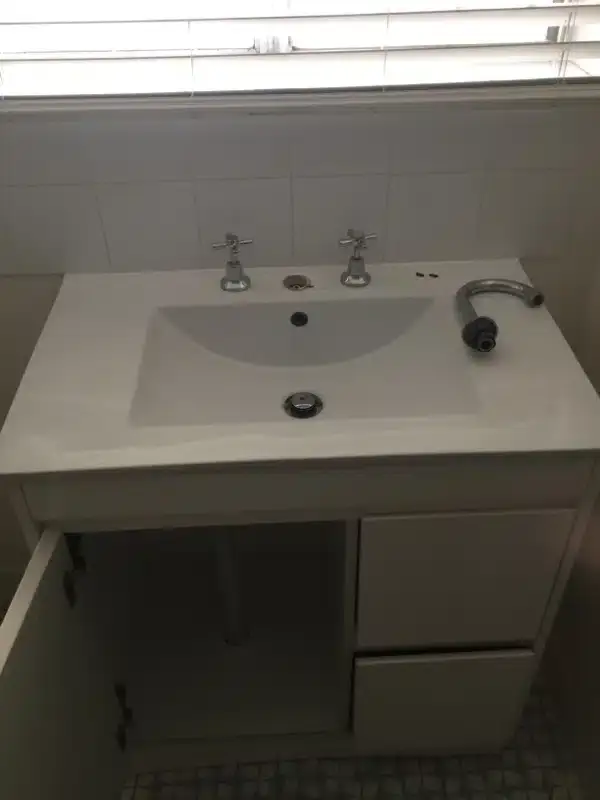 Existing bathroom vanity unit with the cupboard door open
