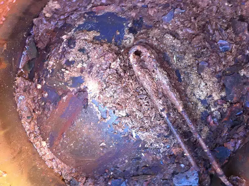 Rust and sediment inside an old hot water system tank