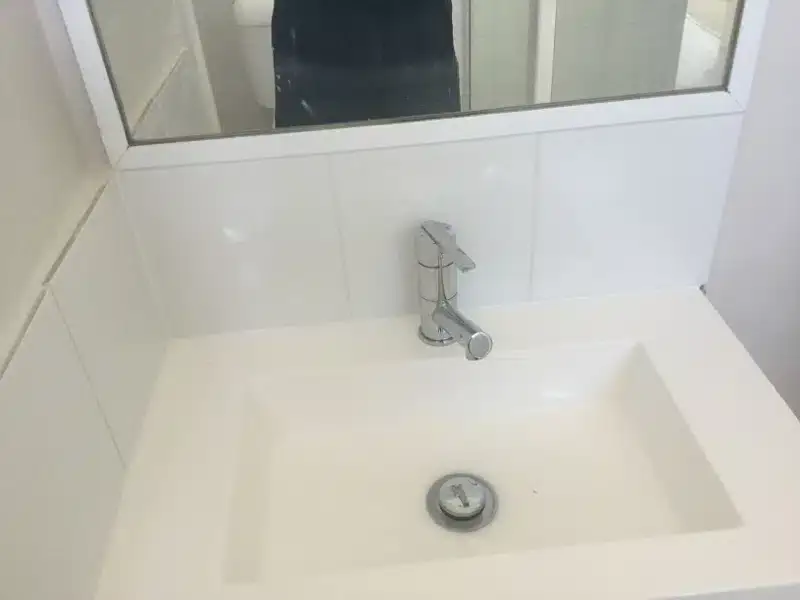 New white basin and mixer tap with fresh wall tiles