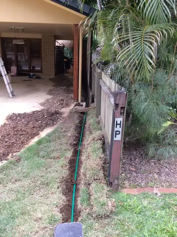 New water main laid in a trench across a front lawn